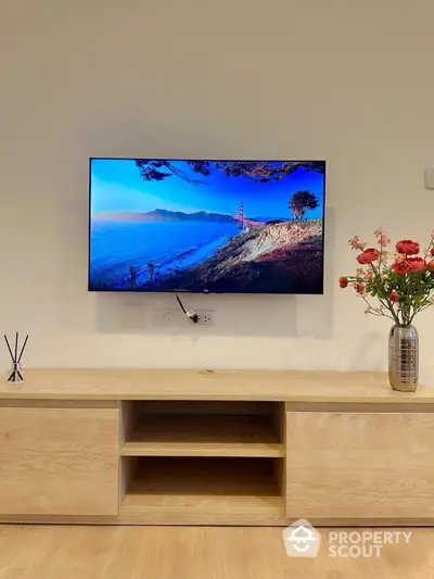 Modern living room with wall-mounted TV and elegant wooden cabinet