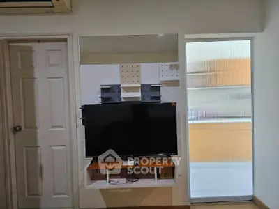 Modern living room with wall-mounted TV and sleek storage solutions.