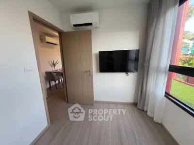 Modern apartment interior with air conditioning and wall-mounted TV, featuring a view of the dining area.