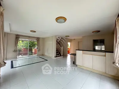 Spacious open-plan living room with large windows and garden view.