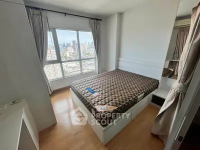 Modern bedroom with city view, featuring large window and stylish decor in urban apartment.