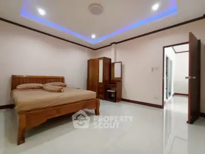 Spacious bedroom with modern lighting and wooden furniture