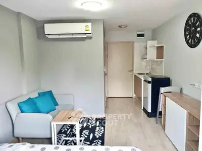 Modern studio apartment with compact kitchen and cozy living area, ideal for urban living.