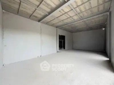 Spacious unfinished interior space with high ceilings and concrete walls, ideal for customization.