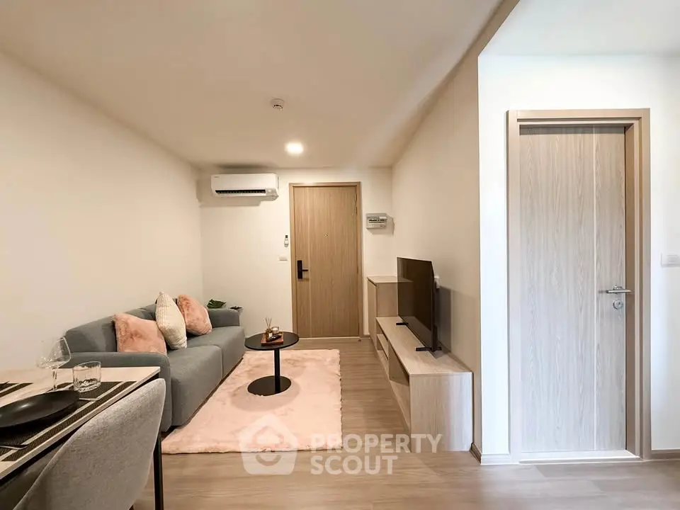Modern living room with cozy sofa, TV, and stylish decor in a contemporary apartment.
