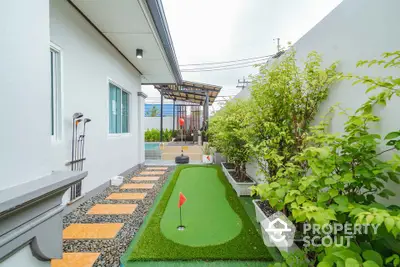 Charming backyard with mini golf putting green and lush greenery for relaxation and entertainment.