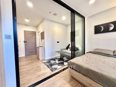Modern bedroom with glass partition and stylish decor in a cozy apartment.
