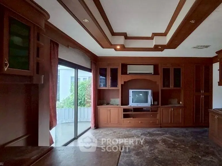 Spacious living room with elegant wooden cabinetry and large windows