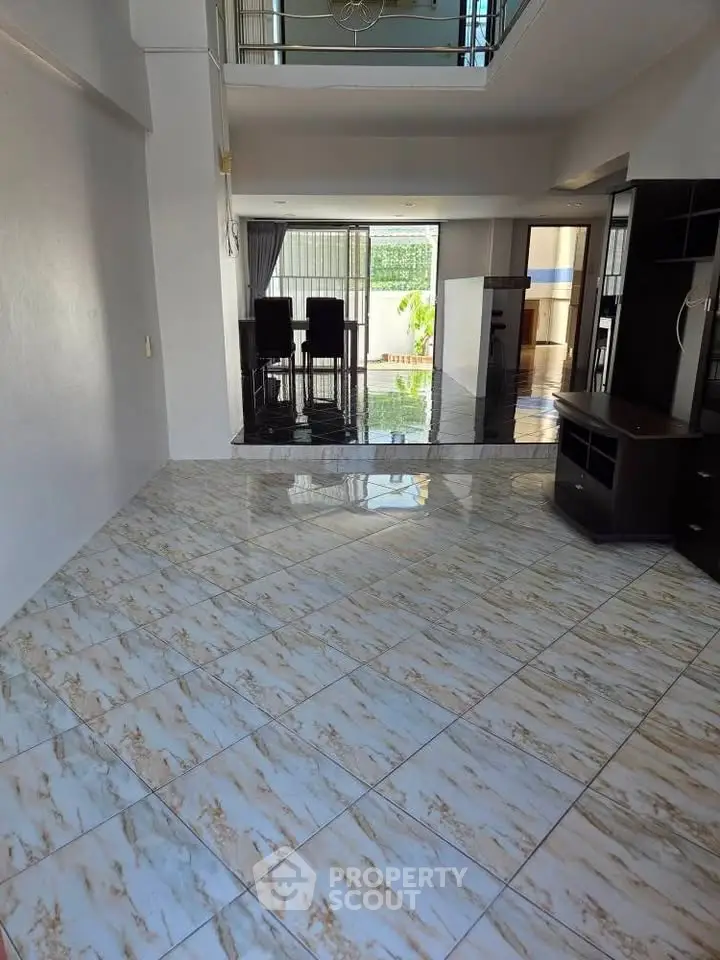 Spacious open-plan living area with glossy tiled floors and modern dining space.