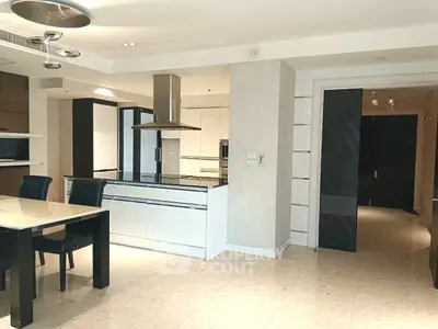 Modern kitchen with sleek design and open layout, featuring elegant dining area and contemporary lighting.