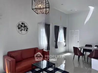 Modern living room with stylish decor, featuring a red sofa, elegant dining area, and large windows for natural light.