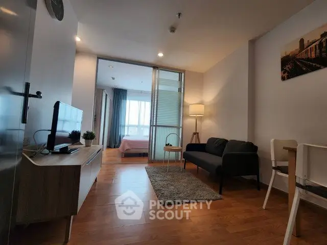 Modern apartment with open living room and bedroom, featuring stylish decor and natural light.