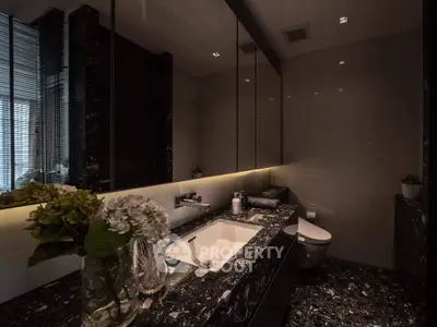 Luxurious modern bathroom with sleek black marble and elegant lighting