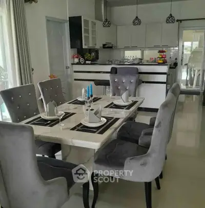 Elegant dining area with plush chairs and modern kitchen in open layout