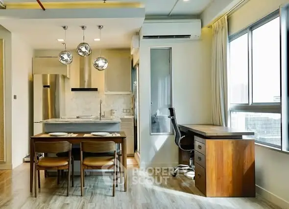 Modern apartment interior with open kitchen and dining area, featuring stylish lighting and wooden furniture.