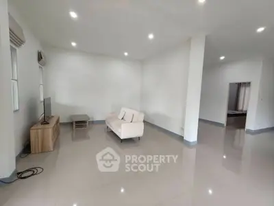 Spacious living room with minimalist decor and ample natural light.