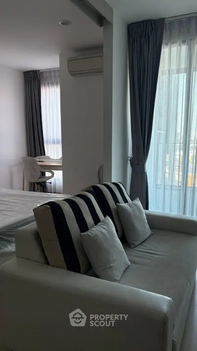 Modern living room with stylish sofa and natural light from large windows.