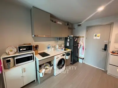 Modern kitchen with integrated appliances and sleek cabinetry in a cozy apartment.