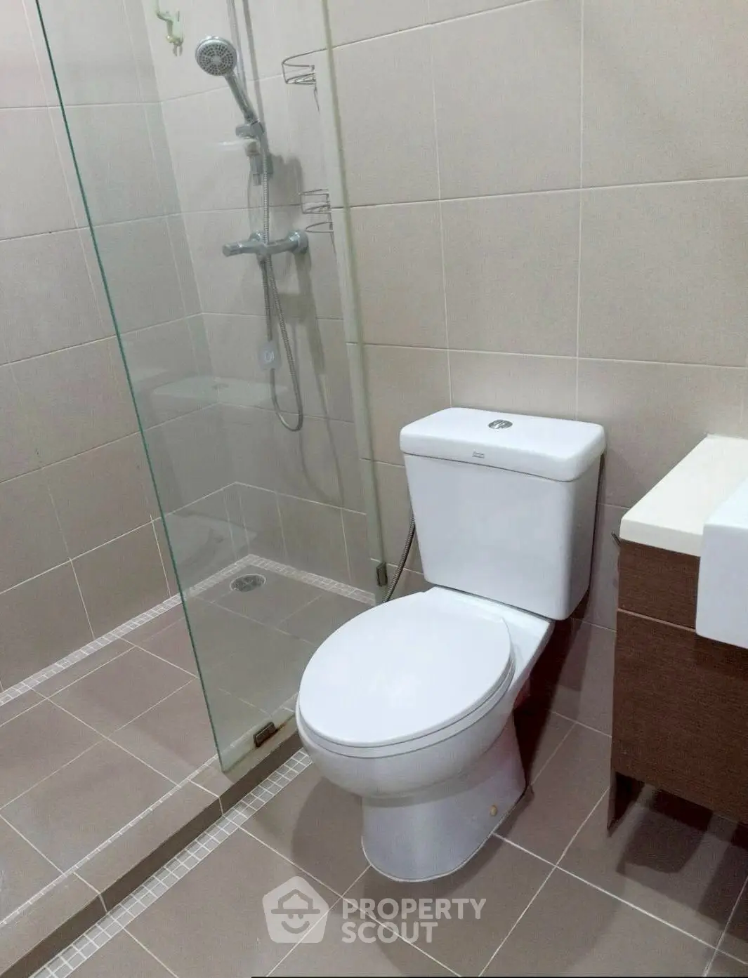 Modern bathroom with glass shower and sleek fixtures in real estate property.
