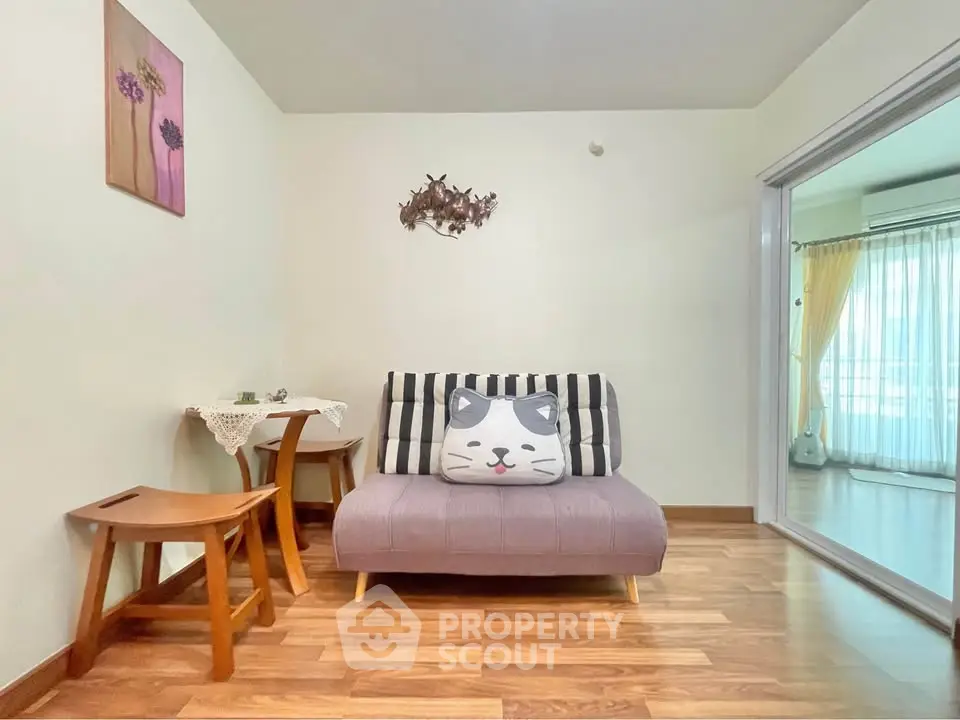 Charming living room with cozy seating and wooden flooring, perfect for relaxation.