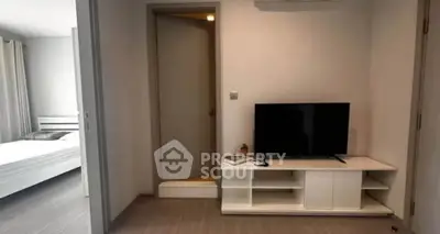 Modern apartment interior with cozy living room and adjacent bedroom, featuring sleek furniture and neutral tones.