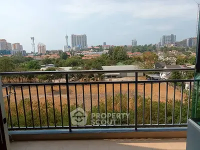 Stunning balcony view overlooking cityscape with lush greenery and skyline.