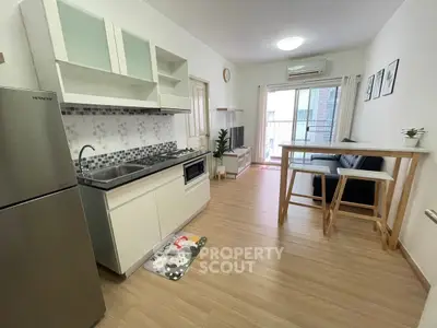 Modern open-layout kitchen and living area with balcony access in stylish apartment.