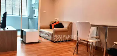 Modern living room with cozy sofa and dining area, featuring sleek wooden flooring.