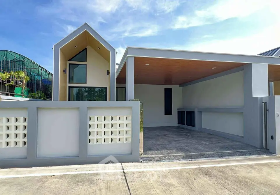 Modern minimalist house exterior with spacious driveway and sleek architectural design.