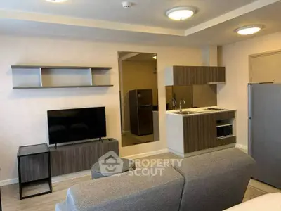 Modern living room with sleek kitchen and stylish furniture in open layout apartment.