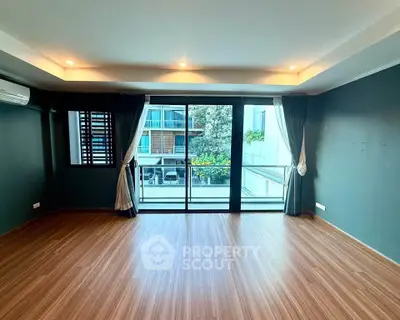 Spacious living room with large windows and balcony access in modern apartment.