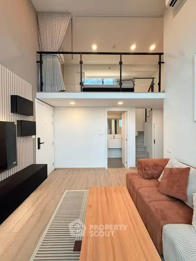 Modern loft apartment with stylish living room and mezzanine bedroom, featuring sleek design and cozy ambiance.