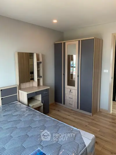 Modern bedroom with stylish wardrobe and vanity set, featuring wooden flooring and contemporary design.