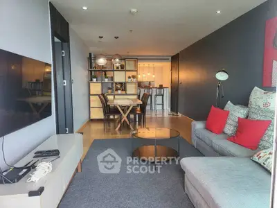 Modern living room with stylish decor and open dining area in a cozy apartment.