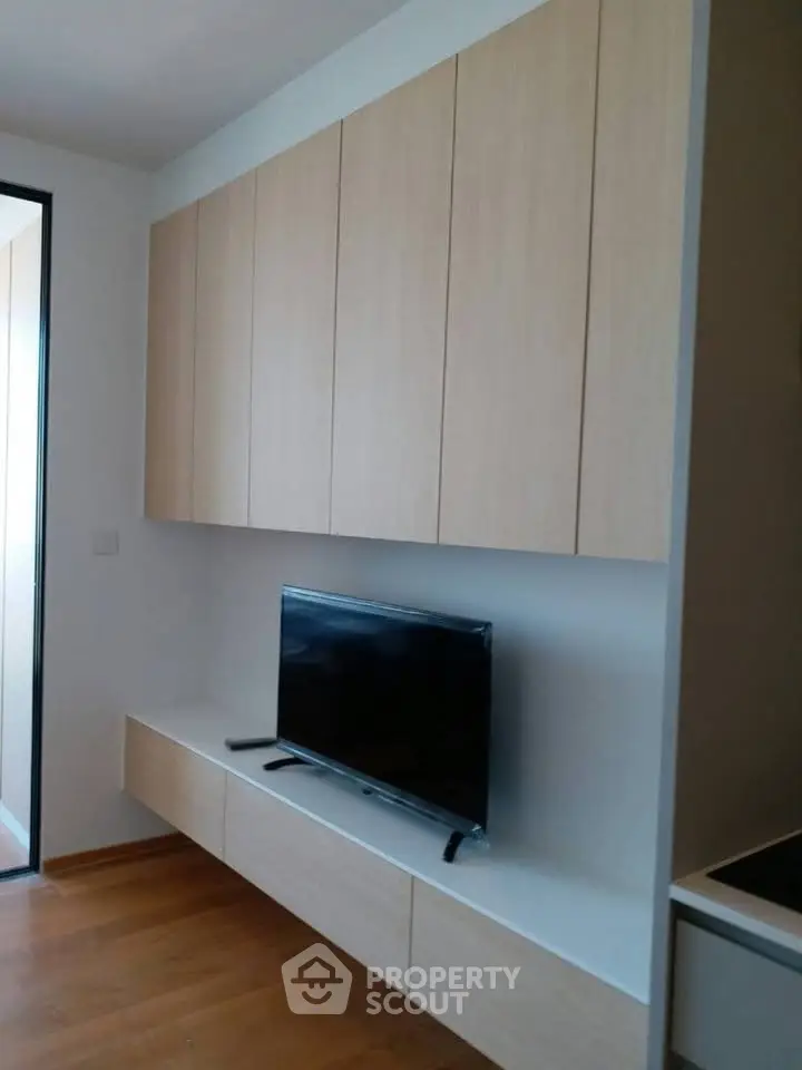 Modern living room with sleek cabinetry and mounted TV, showcasing minimalist design.