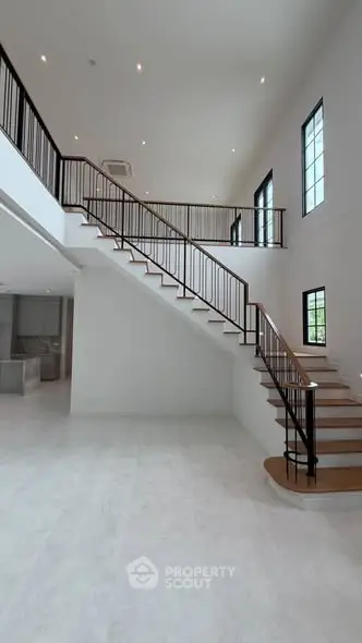 Spacious modern living room with elegant staircase and high ceilings