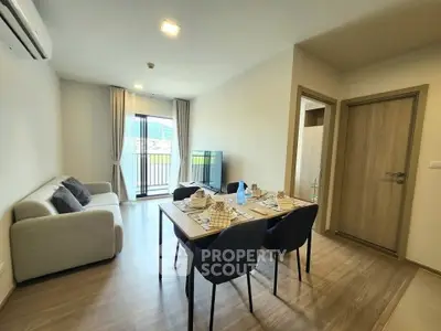 Modern living room with dining area and balcony view in a stylish apartment.