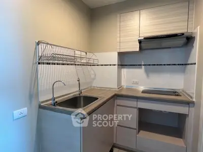Modern compact kitchen with sleek cabinetry and electric stove