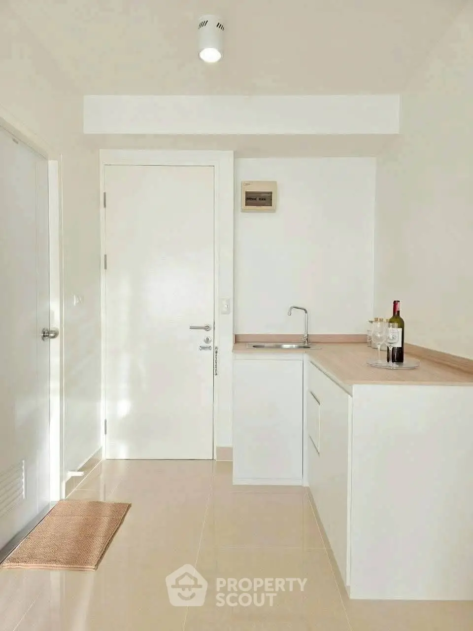 Modern minimalist kitchen with sleek white cabinetry and compact design, perfect for urban living.