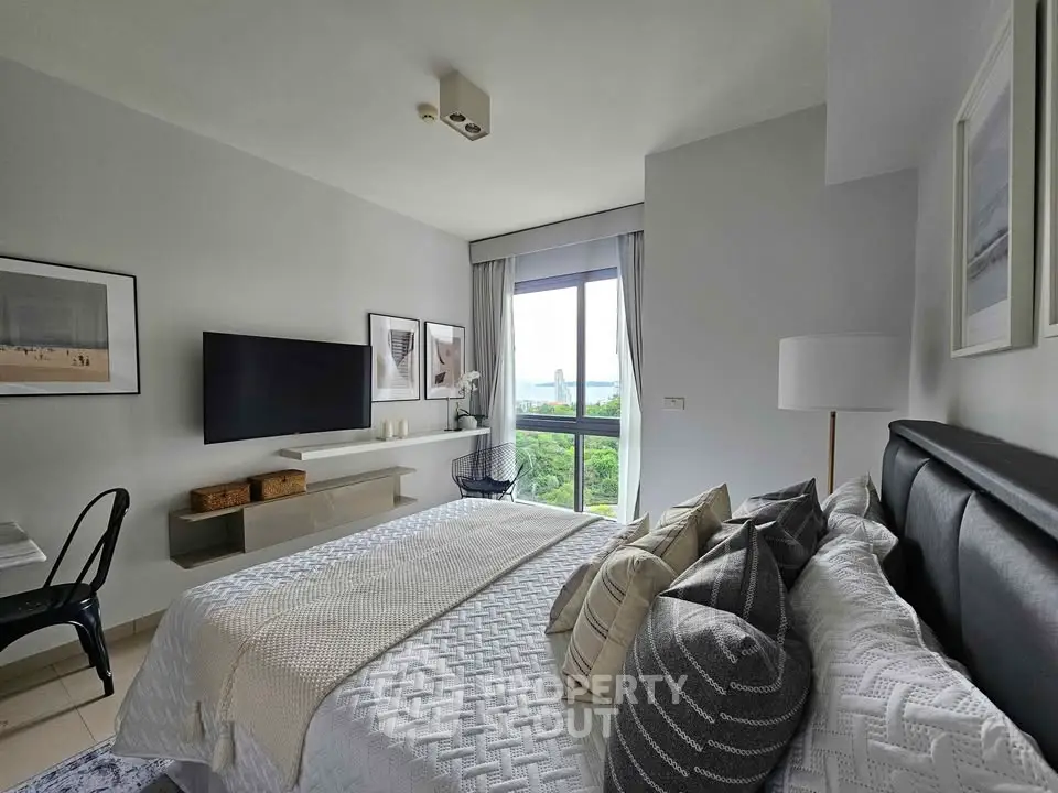 Modern bedroom with stylish decor and large window offering scenic views