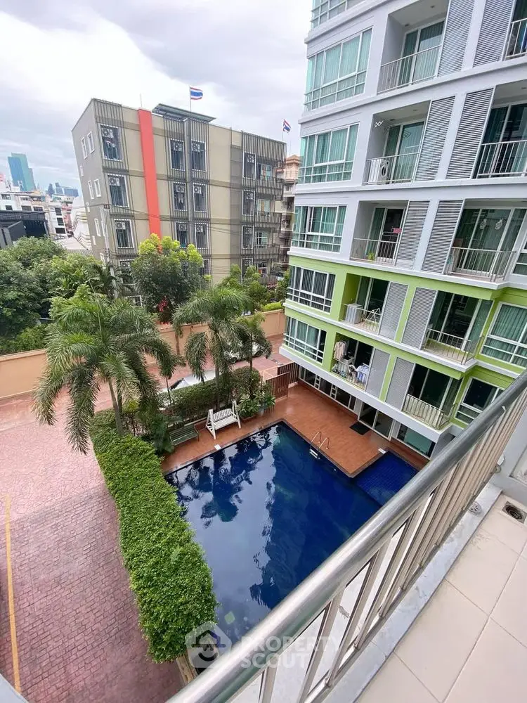 Modern apartment building with pool view and lush greenery