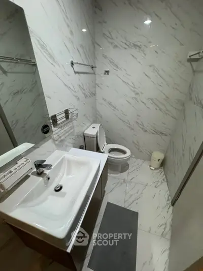 Modern bathroom with sleek marble tiles and contemporary fixtures.