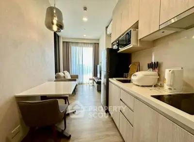 Modern open-layout kitchen with sleek appliances and cozy living area in a stylish apartment.