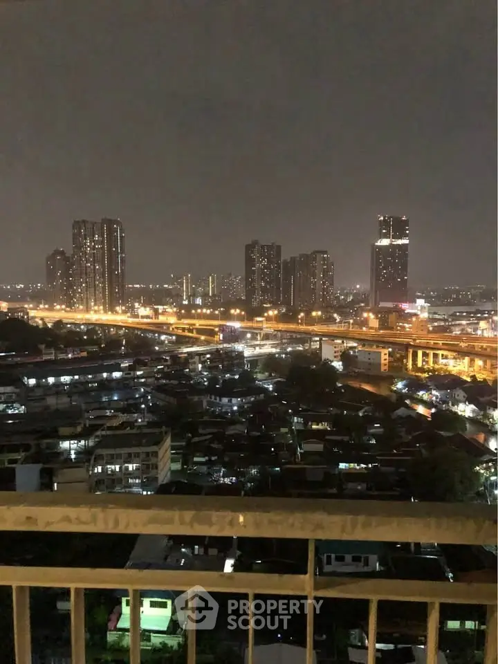 Stunning cityscape view from a high-rise balcony at night with illuminated skyline.