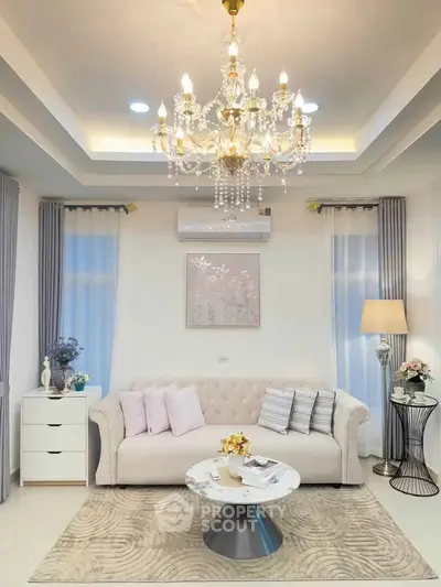 Elegant living room with chandelier, plush sofa, and modern decor