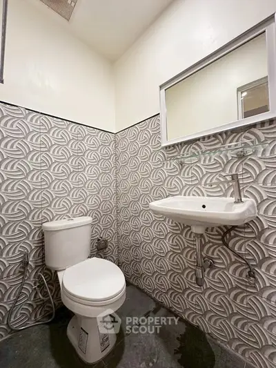 Modern bathroom with stylish geometric tile design and sleek fixtures.