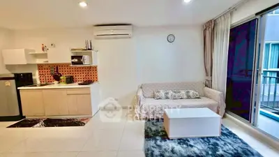 Modern living room with open kitchen and balcony access in stylish apartment.