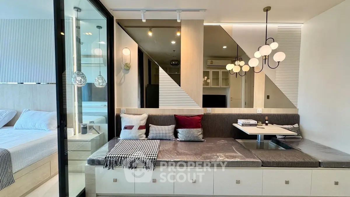 Modern living room with stylish decor and cozy seating area, adjacent to a chic bedroom.