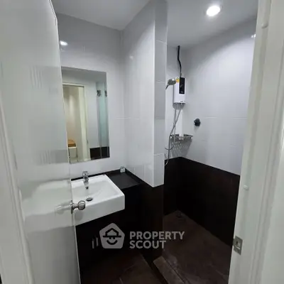 Modern bathroom with sleek fixtures and a compact shower area, perfect for urban living.