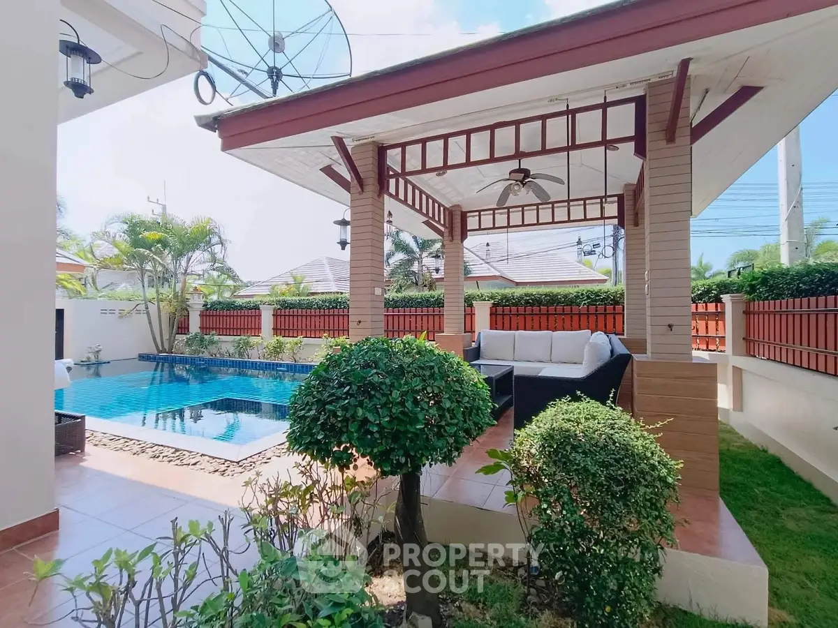 Charming outdoor patio with pool and cozy seating area in tropical setting